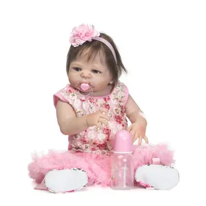 Realistic reborn baby doll girl in pink floral dress with pacifier and bottle accessories