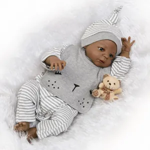 Poupée bébé Reborn noire réaliste en tenue rayée avec un ours en peluche sur tapis