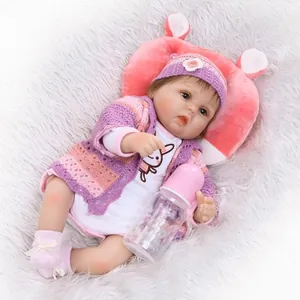 Poupée bébé reborn réaliste en tenue tricotée rose sur fond en peluche blanc doux