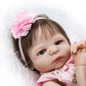 Realistic reborn baby doll with blue eyes and floral headband on soft white fur background