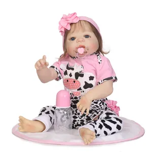 Realistic reborn baby doll with cow print outfit, headband, pacifier and bottle