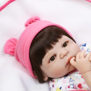 Realistic reborn baby doll with pink knit hat and detailed facial features in close-up