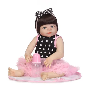 Realistic reborn baby doll with blue eyes and pink lace dress, including bottle and pacifier