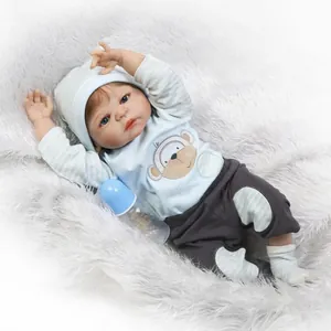 Realistic reborn baby doll in blue striped outfit with monkey pattern and bottle on rug