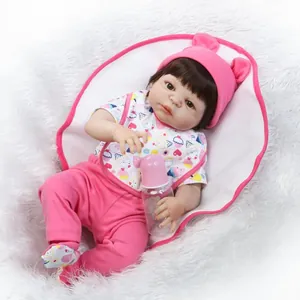 Realistic reborn baby doll with pink rabbit ear hat and matching outfit holding a bottle