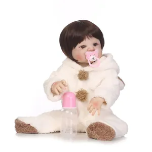 Reborn baby doll in white plush jumpsuit with magnetic pacifier and bottle set