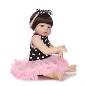 Realistic reborn baby doll with brown hair and blue eyes in a pink tutu skirt