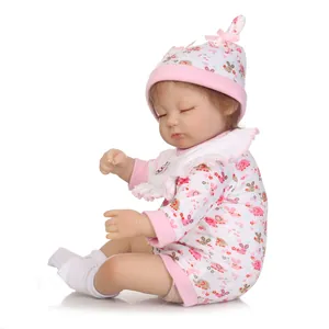 Realistic sleeping baby doll in floral pink outfit and pointed hat on white background