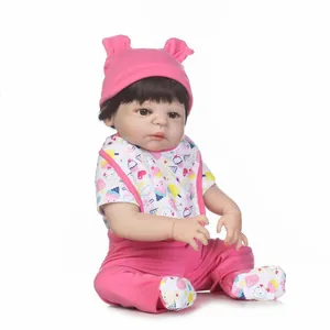Lifelike reborn baby doll in pink ice cream outfit and bear hat on white background
