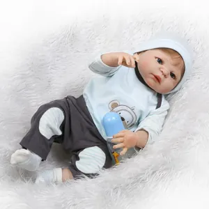 Realistic reborn baby doll in blue monkey outfit on white plush rug with nursing bottle