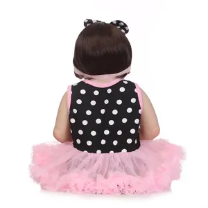 Realistic reborn baby doll in polka dot dress with pink tutu and hair bow, back view