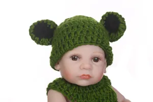 Macro view of hand-knitted green baby animal hat and matching neck warmer for photography