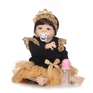 Poupée reborn réaliste avec cheveux bruns et robe en dentelle noire et dorée