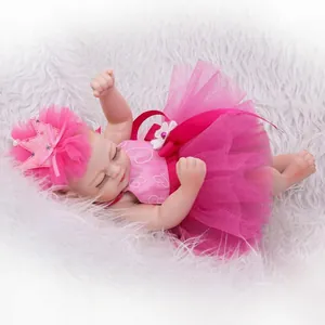Realistic reborn baby doll in pink tutu and crown headband sleeping on plush white fur