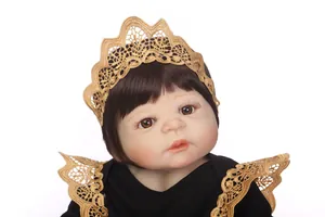 Détail d'une poupée reborn avec couronne en dentelle dorée et traits fins du visage