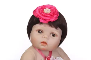 Détail d'une poupée avec bandeau fleur en satin rose vif et perles blanches de luxe