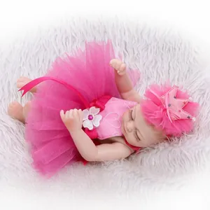Realistic reborn baby doll in pink tutu dress sleeping on soft white plush background