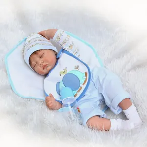 Poupée nouveau-né réaliste en tenue bleue avec biberon sur tapis en peluche