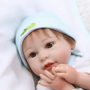 Realistic reborn baby doll with brown hair and blue striped hat for girls play