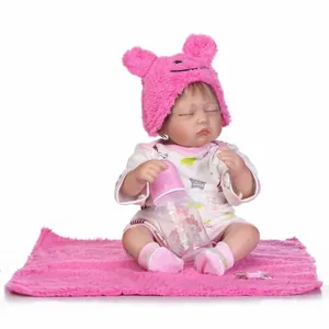 Poupée bébé réaliste endormie avec bonnet animal rose, barboteuse blanche et biberon