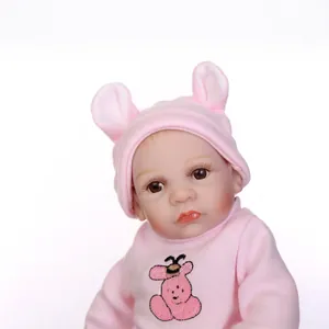 Poupée bébé Reborn réaliste en tenue d'ours rose avec texture de peau sur fond blanc
