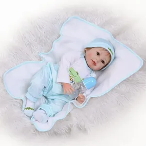 Realistic reborn baby doll in blue outfit with bottle on soft quilted infant mat