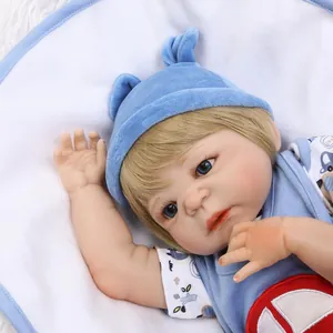 Realistic 0-3 months reborn baby doll with blue eyes and blue knitted hat on soft white fur