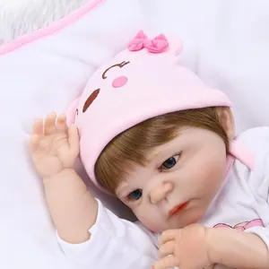 Realistische reborn babypop meisje met roze muts en witte kleding op wit beddengoed