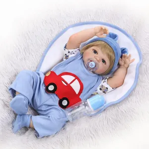 Lifelike newborn baby doll in blue car outfit with pacifier on plush grey rug