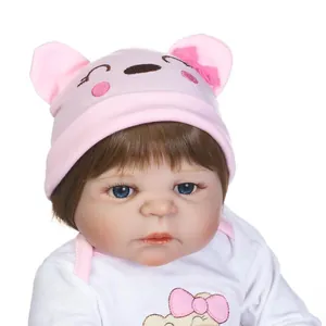 Realistische reborn babypop met blauwe ogen, roze gebreide muts en witte romper