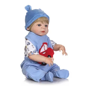 Realistic newborn baby doll with blue eyes and blue car outfit on white background