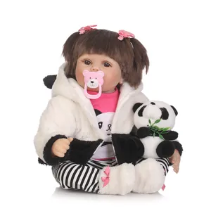 Poupée réaliste nouveau-né en tenue de panda avec peluche sur fond blanc épuré