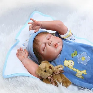Realistic sleeping newborn baby doll in blue giraffe outfit with small teddy bear accessory