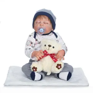 Lifelike reborn baby doll in polka dot outfit sleeping with a teddy bear and pacifier