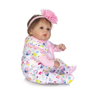 Lifelike reborn baby doll with brown hair in pink floral outfit and flower headband