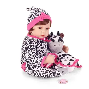 Realistic newborn baby doll in cow pattern romper with plush toy and brown hair