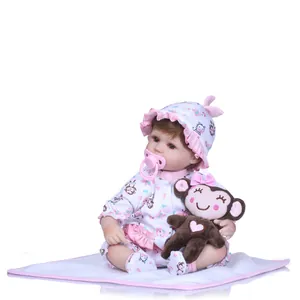 Lifelike reborn baby doll in pink floral monkey outfit with plush toy and pacifier