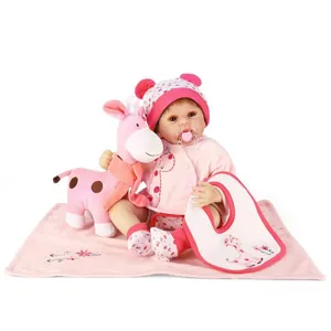 Realistic silicone baby doll set with pink giraffe plush and accessories on white backdrop