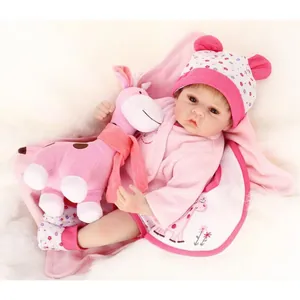 Realistic reborn baby doll in pink floral outfit with a matching giraffe plush toy