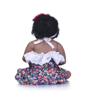 Vue de dos d'une poupée noire aux cheveux bouclés portant une robe à fleurs et un bandeau
