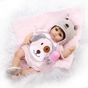 Realistic reborn baby doll in pink striped outfit with grey bear ear hat and bottle