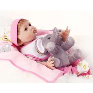 Realistic reborn baby doll in pink polka dot outfit holding a grey plush elephant toy