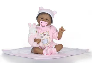 Détails d'une poupée reborn à la peau foncée en tenue d'ours rose avec lapin en peluche
