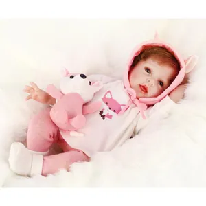 Realistic reborn baby doll in pink fox outfit with matching plush toy on white fur