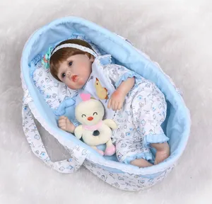 Detailed view of reborn baby doll in a blue lace carrier with a plush duck toy accessory