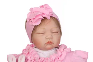 Détail d'un bandeau rose avec fleurs en tissu sur une poupée bébé réaliste