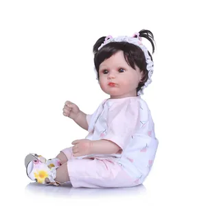Realistic 40cm reborn baby doll with curly brown hair in pink floral outfit and headband