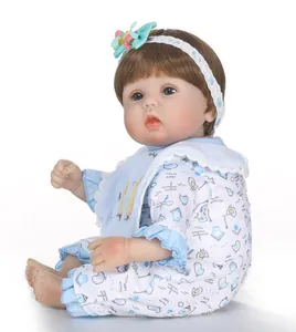 Detailed close-up of a realistic reborn baby doll with blue eyes and blue bow headband