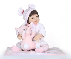 Realistic newborn baby doll with pink striped hat and small plush elephant accessory