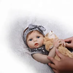 Poupée bébé reborn réaliste avec haut à paillettes gris et petit ours en peluche